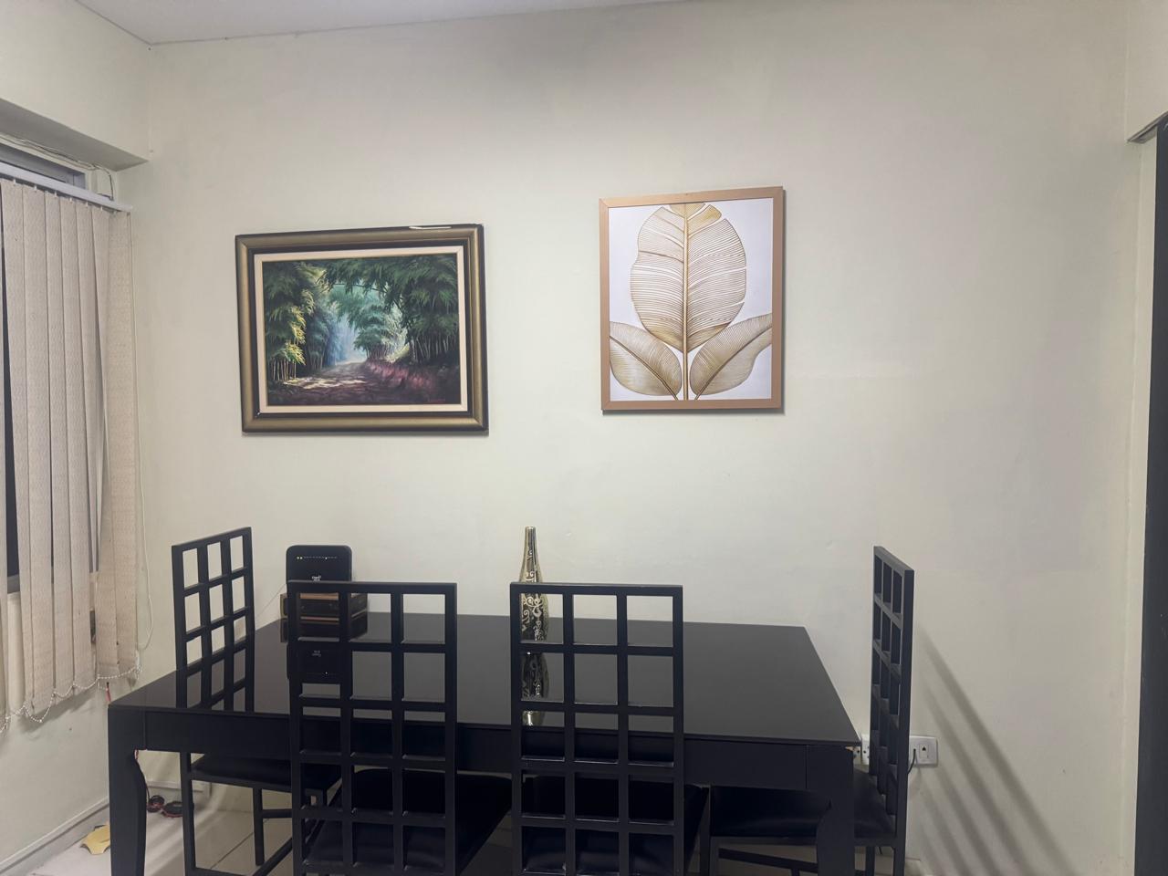 Sala com mesa de reuni&atilde;o, cadeiras e quadros na parede